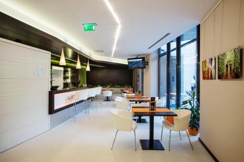 a restaurant with tables and chairs and a bar at Art Hotel Szeged in Szeged