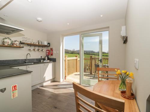 a kitchen and dining room with a table and a patio at The Attic at Redmond Bottom in Wells