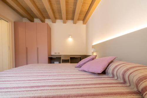 ein Schlafzimmer mit einem großen Bett mit lila Kissen in der Unterkunft Il Giardino Segreto in Cividale del Friuli