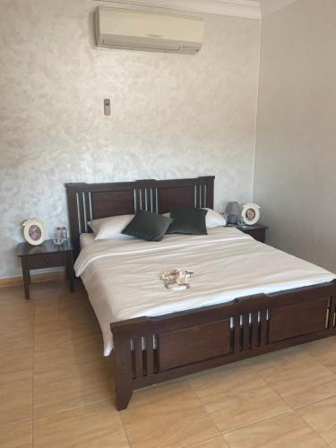 1 dormitorio con 1 cama grande con sábanas y almohadas blancas en شاليه على البحر UAE, Abu Dhabi, en Baţīn