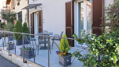 a balcony with plants and a table and chairs at Italianway - Affittacamere Brenna in Como