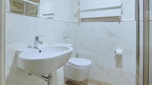 a white bathroom with a sink and a toilet at Italianway - Affittacamere Brenna in Como