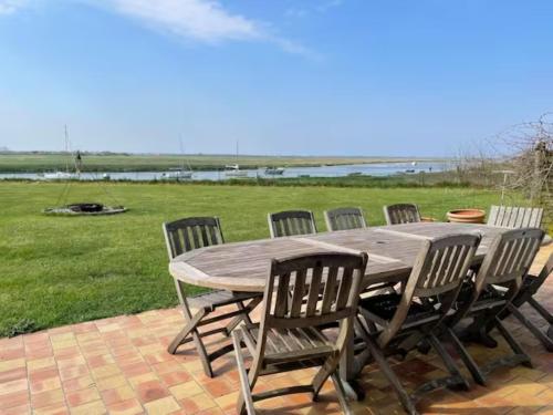 une table et des chaises en bois sur une terrasse dans l'établissement Maison avec piscine au milieu de la Baie d'Authie, à Waben