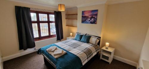 1 dormitorio con cama y ventana en VH, 4 BR House, Upwell, Wisbech, en Upwell