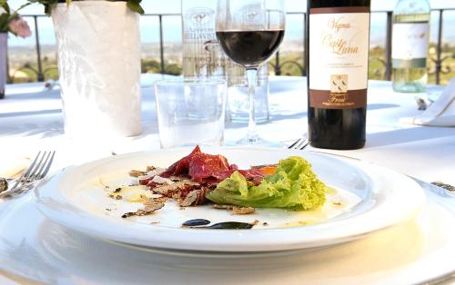 a plate of food on a table with a bottle of wine at Agriturismo Bellavista in San Miniato