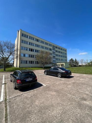 two cars parked in a parking lot in front of a building at H1 Herberge-One Erfurt in Erfurt