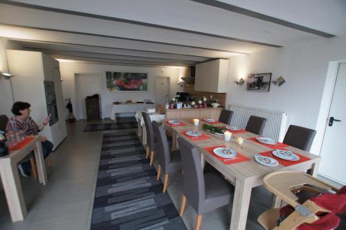 uma sala de jantar com uma mesa longa e cadeiras em Pension Obstgarten em Laupheim