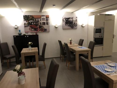 uma sala de jantar com mesas e cadeiras e uma cozinha em Pension Obstgarten em Laupheim