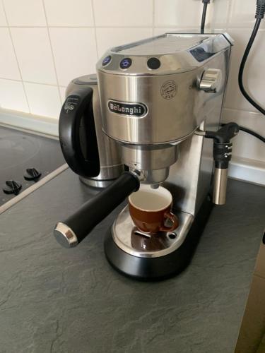 a coffee maker sitting on a counter with a cup of coffee at Le Café Crème jardin parking in Le Chambon-sur-Lignon