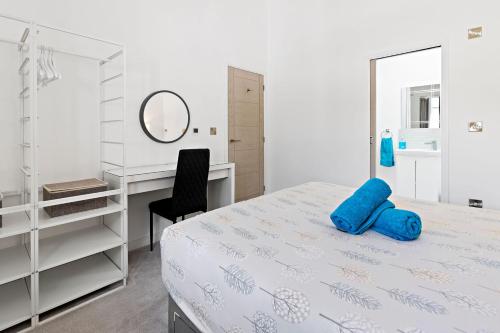 Schlafzimmer mit einem Bett, einem Schreibtisch und einem Spiegel in der Unterkunft Anchor View at Grand Banks, Teignmouth in Teignmouth