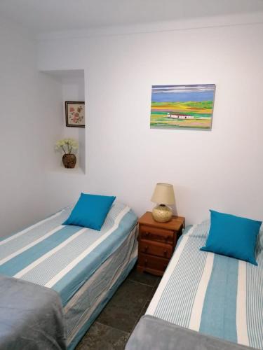 a bedroom with two beds and a table with a lamp at CASA DA ALAMEDA in Nisa