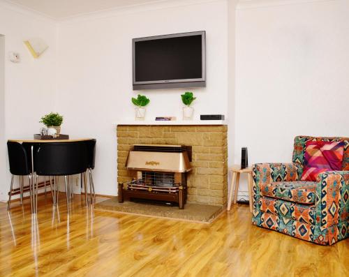 uma sala de estar com lareira e uma televisão na parede em 33SM Dreams Unlimited Serviced Accommodation- Staines - Heathrow em Stanwell