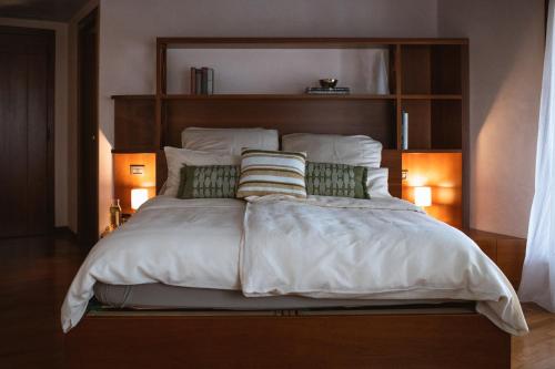 una camera da letto con un grande letto bianco con due cuscini di Villa Cavaion a Cavaion Veronese