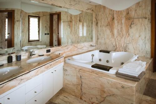 bagno con vasca, 2 lavandini e specchio di Villa Cavaion a Cavaion Veronese
