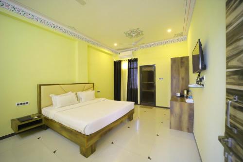 a bedroom with a bed and a flat screen tv at The Sky Comfort Shiv Ashray Resort in Nāthdwāra