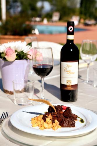 a plate of food and a bottle of wine on a table at Agriturismo Bellavista in San Miniato