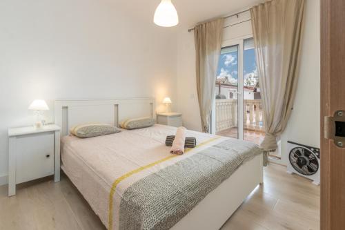 a bedroom with a large bed and a balcony at Villa Terrassa in Sant Antoni de Calonge