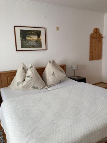1 dormitorio con 1 cama con sábanas y almohadas blancas en Appartementhaus Dargham en Strobl