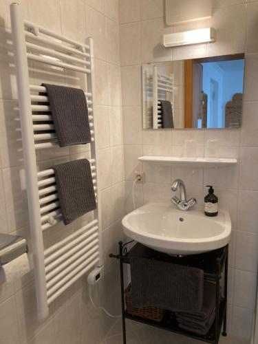 ein weißes Badezimmer mit einem Waschbecken und einem Spiegel in der Unterkunft Appartementhaus Dargham in Strobl