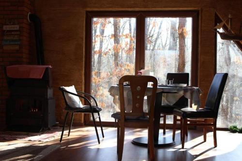 a table and chairs in a room with a window at Cozy 3 bedroom mountain villa with scenic views in Novoberdo