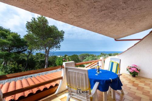 une table et des chaises sur le balcon d'une maison dans l'établissement Apartments Casa Vacanze Porto Pino, à Porto Pino