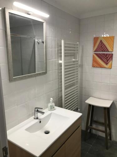a bathroom with a sink and a mirror and a stool at CASA DA ALAMEDA in Nisa