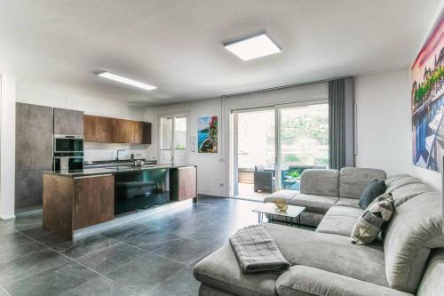 a living room with a couch and a kitchen at Como In Centro - by MyHomeInComo in Como