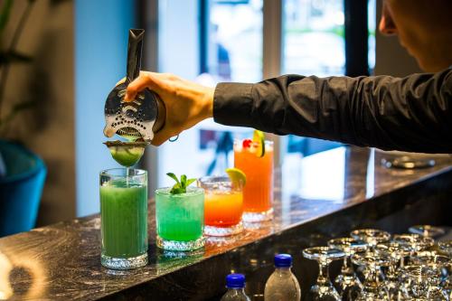 a bartender making a green drink at a bar at Mercure Riga Centre in Rīga