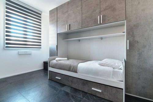 a bedroom with a bed and cabinets and a window at Como In Centro - by MyHomeInComo in Como