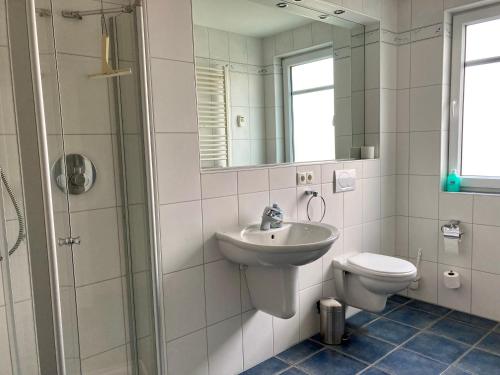 ヴァンガーオーゲにあるVilla Puccini Whg. 4のバスルーム(洗面台、トイレ、鏡付)