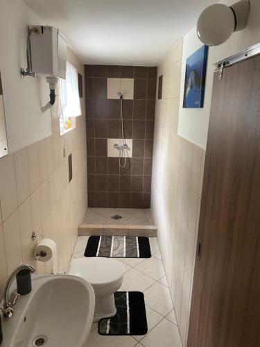 a small bathroom with a toilet and a sink at Relax Island Vendégház in Sátoraljaújhely