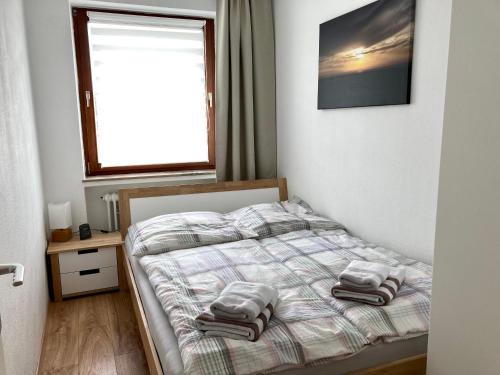 a bedroom with a bed with two towels on it at Anton-Gunther-Str 16 in Wangerooge