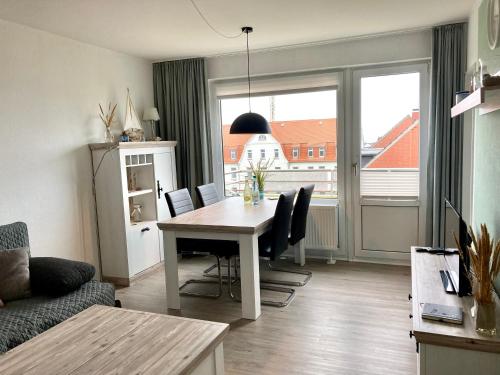 a living room with a table and a large window at Duene 30 in Wangerooge