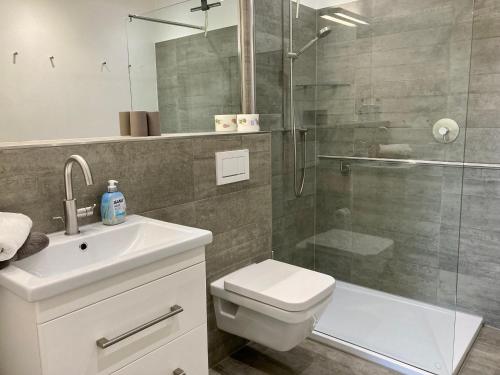 La salle de bains est pourvue d'un lavabo et d'une douche. dans l'établissement Residenz am Rosengarten 16, à Wangerooge