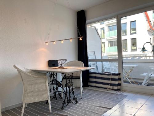 einen Tisch und Stühle in einem Zimmer mit Fenster in der Unterkunft Haus Seeluft Whg 11 in Wangerooge