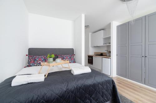 a bedroom with a black bed with a table on it at Elegant Pet-Friendly Studio in Krakow by Renters in Krakow