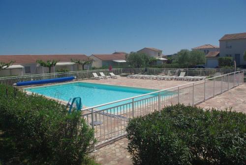 une piscine entourée d'une clôture métallique. dans l'établissement Résidence A NUCIOLA Les pieds dans l'eau Cervione Hte CORSE, à Cervione
