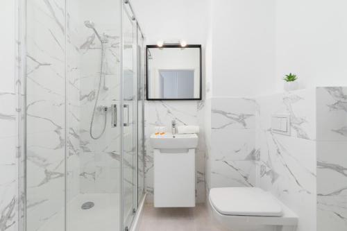 a white bathroom with a sink and a mirror at Elegant Pet-Friendly Studio in Krakow by Renters in Krakow