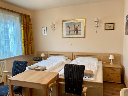 1 Schlafzimmer mit 2 Betten, einem Tisch, einem Tisch und Stühlen in der Unterkunft Haus Stortebeker Whg 4 in Wangerooge