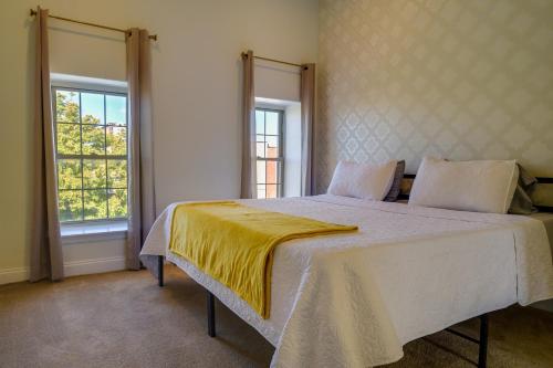 a bedroom with a bed with a yellow blanket on it at Quaint Baltimore Townhouse about 1 Mi to Inner Harbor! in Baltimore