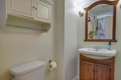 a bathroom with a toilet and a sink and a mirror at Quaint Baltimore Townhouse about 1 Mi to Inner Harbor! in Baltimore
