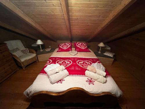 - une chambre avec un grand lit et des couvertures rouges et blanches dans l'établissement Chalet le Pré de la Dame, à Épagny