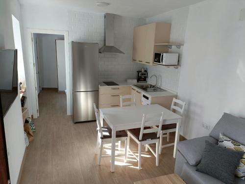 メディナ・シドニアにあるEl barrioのテーブルと冷蔵庫のあるキッチンとダイニングルーム