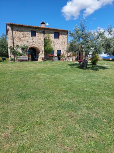 a stone building with a grass field in front of it at Casetta dell`Uliveto in Macchiascandona