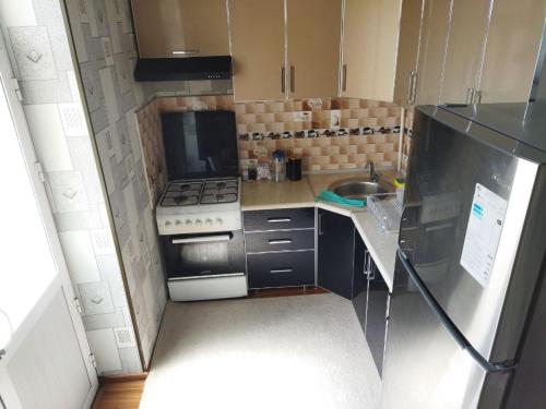 uma pequena cozinha com um fogão e um lavatório em Apartment near Tashkent metro station and convenient location em Tashkent