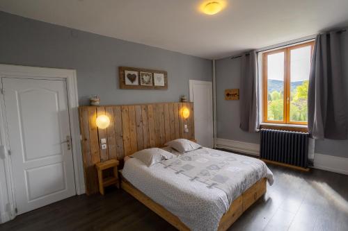 ein Schlafzimmer mit einem großen Bett und einem Fenster in der Unterkunft Gîte 4 à 10 pers in Granges-sur-Vologne