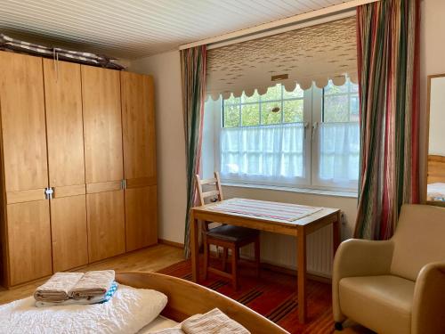ヴァンガーオーゲにあるHaus Fregatte Whg 1のベッドルーム(テーブル、ベッド、窓付)