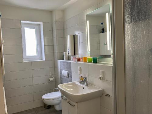 ヴァンガーオーゲにあるHaus Nautica 416のバスルーム(洗面台、トイレ、鏡付)