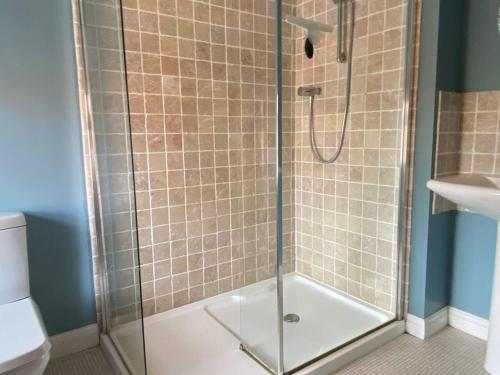 a shower with a glass door in a bathroom at 3 Bedroom Cottage Sleeps 5 village location in Scarborough