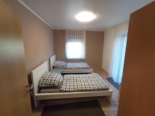 Duas camas num pequeno quarto com uma janela em Niederahr-Hauptstraße 